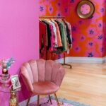 Colorful room with pink armchair and clothing rack creating a chic boutique vibe.